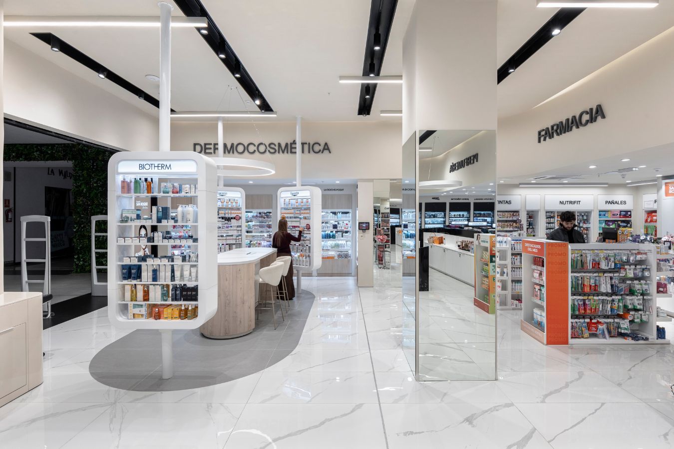 San Roque Pharmacy - Central merchandising island with mirrors and clean white branding - Contract Workplaces.jpg